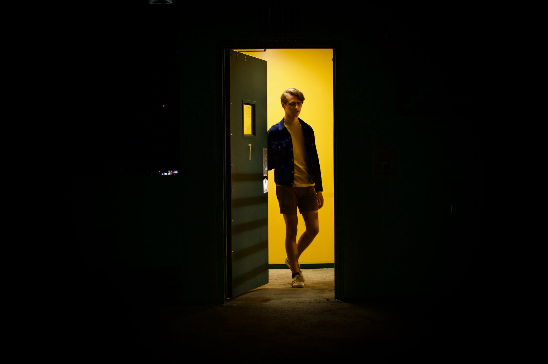 Man opening door to darkness.